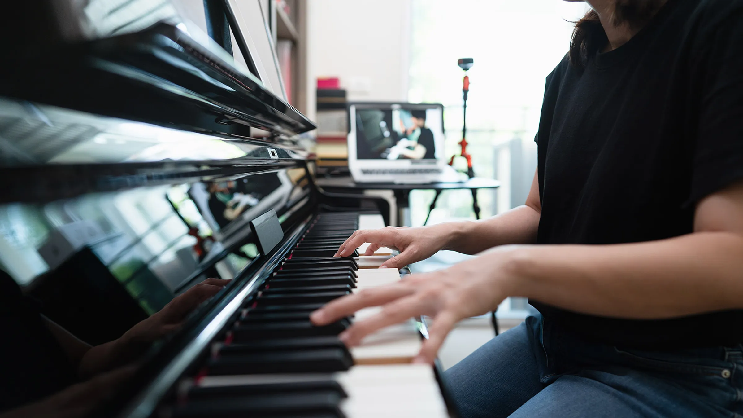 An adult student playing piano at home