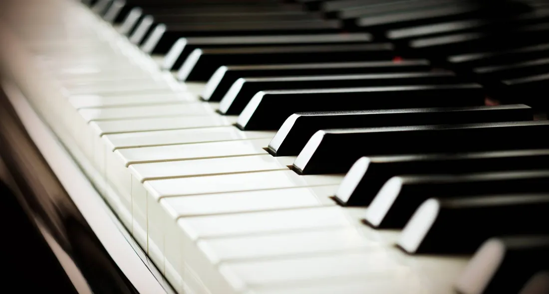 Close-up of piano keys lit in warm light